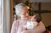 Grandmother holding newborn baby and smiling