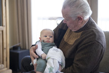grandfather cradling his infant grandson 