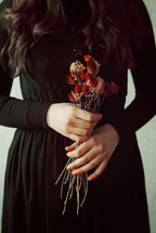 Conceptual Young girl in black vintage dress and dried flowers