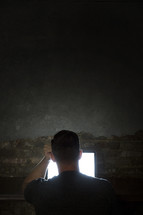man looking at a computer screen in darkness
