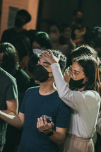 praying over another during a worship service 