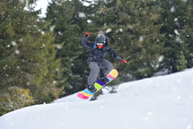 Snowboarder Soaring Through the Air on a Hillside Jump