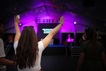 woman with hands raised during a worship service 