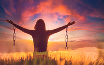 Woman feeling free in a natural setting with broken chains 