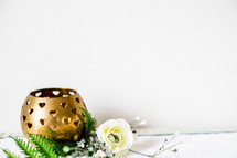 gold candle holding and flowers 