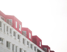 row of windows on a red and white building in fog 