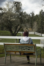a woman sitting on a bench outdoors 
