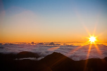 sunrise over mountaintops in the clouds 