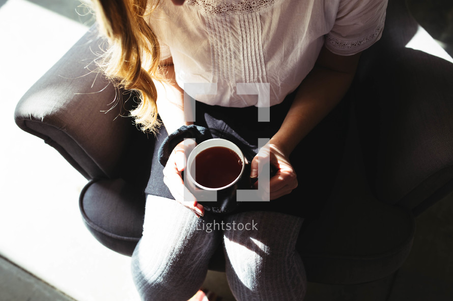 coffee in a mug on a woman's lap 