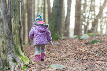 toddler girl exploring the woods 