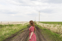 young woman alone on a dirt road 