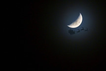 Santa's Sleigh And Reindeer's In Front of Moon On A Clear Blue Sky