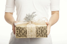 Hands holding out a gold and silver wrapped gift with a bow