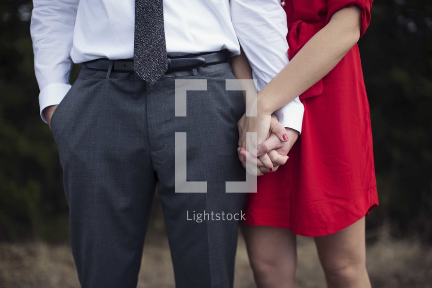 a couple standing together holding hands 