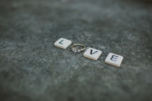 word Love - scrabble pieces and and engagement ring