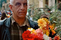 a man carrying a bouquet of flowers 