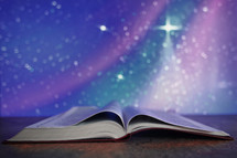 Blue and purple twinkle light stars behind a Bible