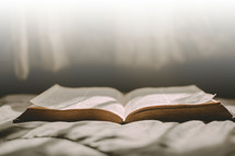 open Bible on a bed 