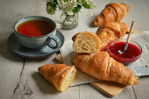 Table with Fresh baked croissant and tea