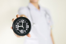 a healthcare worker holding a clock 