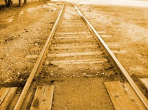 A historic photograph of a set of railroad tracks in a sepia tone color. 