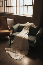 wedding dress drapped across a chair 