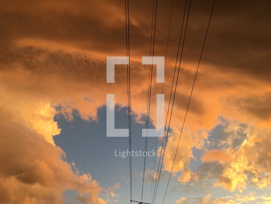 power lines and clouds in the sky at sunset 