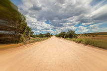 Dirt road with motion blur and clouds