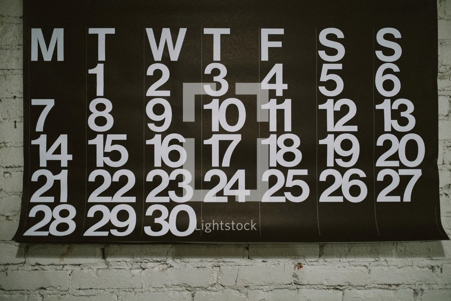 Calendar hung on a brick wall
