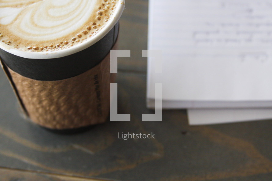 a latte and spiral notebook with notes 