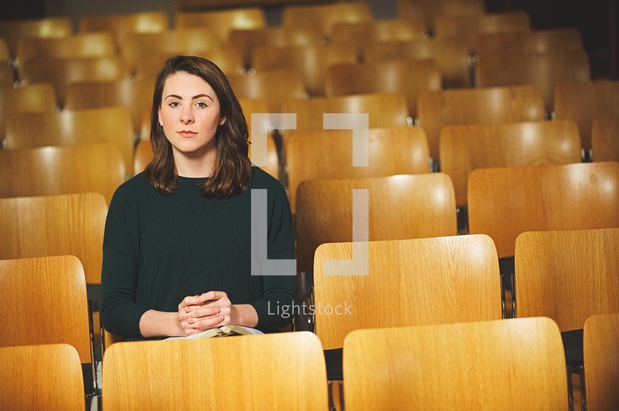a woman praying alone in a church 