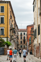 pedestrians walking through Venice alleys 