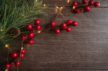 red berries and fairy lights on a wood background 