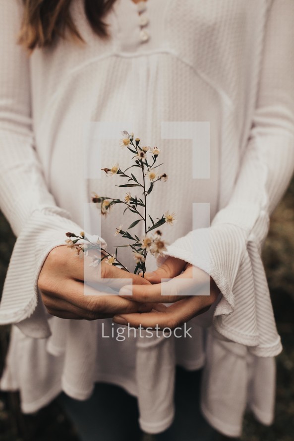 a pregnant woman holding flowers 