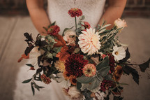 bride holding a bouquet of flowers in fall 