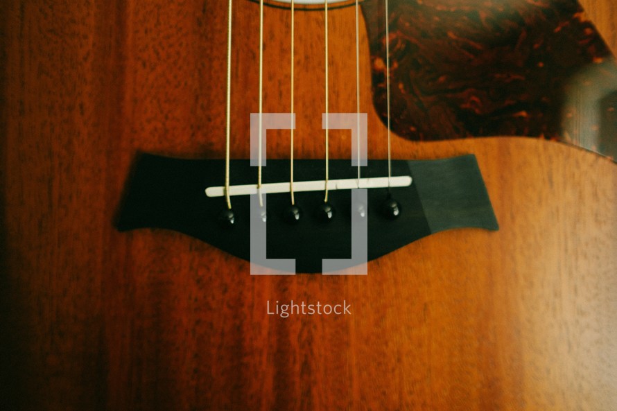 Bridge and strings of a guitar.