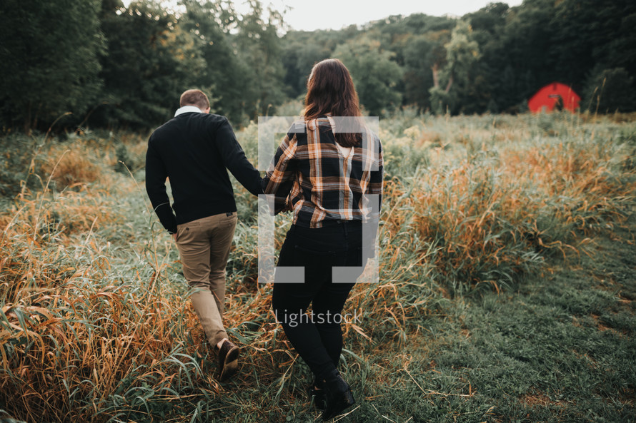 couple walking through a field 