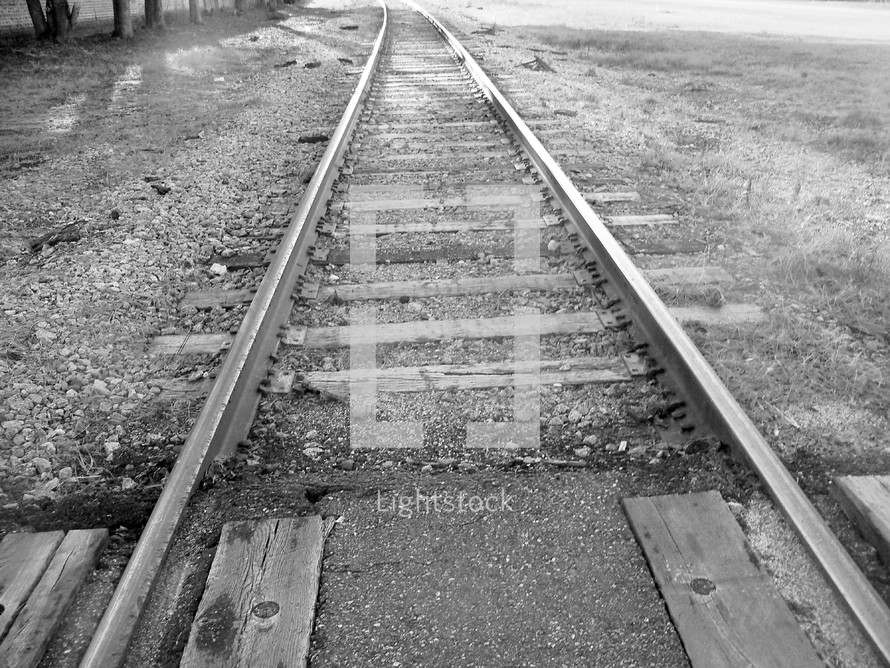 A set of train railroad tracks disappearing into the horizon in this black and white photograph by Rick Short.  