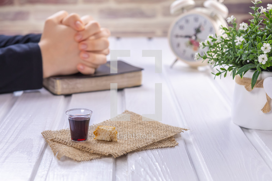 praying hands and communion elements 