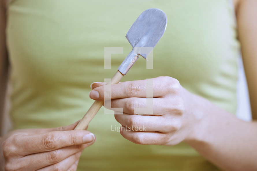 a woman holding a tiny shovel 