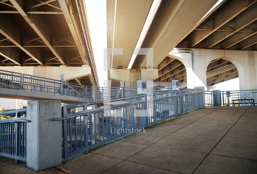 Low angle view of underneath a highway bridge and pedestrian area