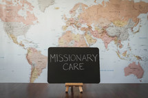 world map and word missionary care on a sign 