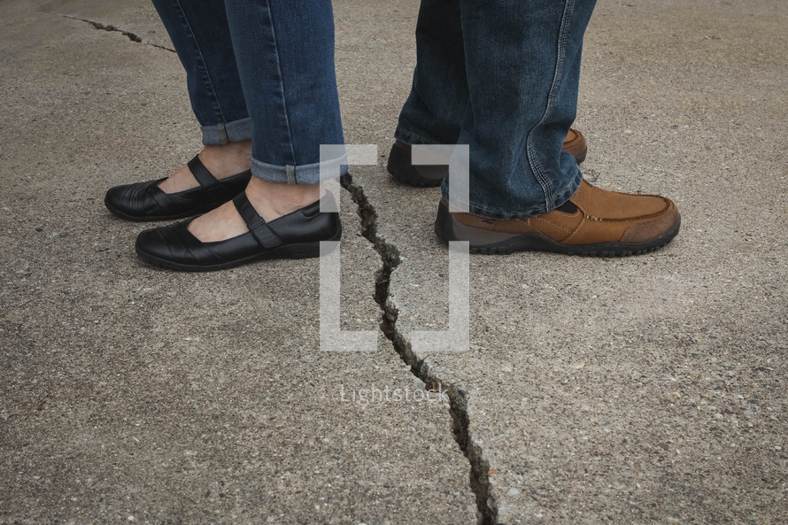 couple standing separated by a crack 