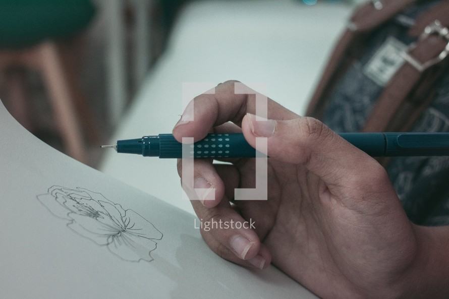a person sketching a flower 