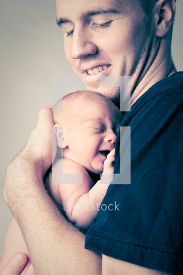 father holding his newborn close to his heart