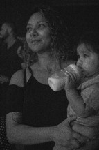 a mother holding an infant during a worship service 