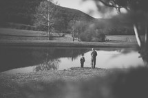a father and son fishing in a pond 