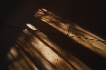 Sunbeam shadows on a vintage rural wooden floor of a dark room