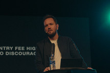 minister on stage giving a sermon during a worship service 