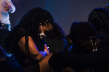 people wearing face masks praying during a worship service 